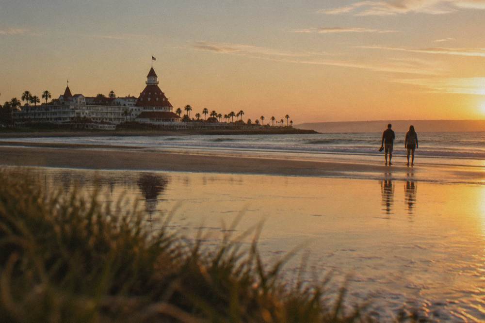 Golden evening light across a wide sandy beach with calm water