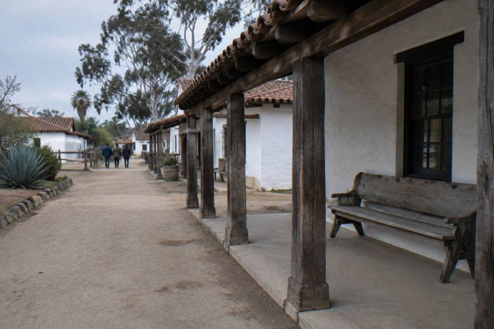 A historic waterfront street in Old Town San Diego with adobe buildings along the sidewalk