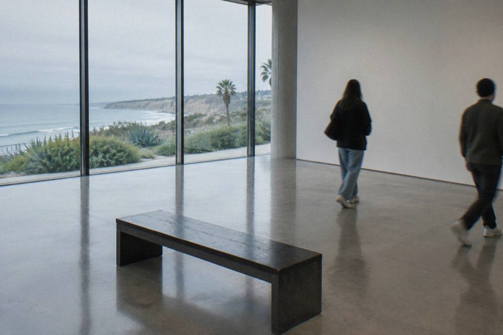Sunlit contemporary art gallery hall with tall windows and open floor space