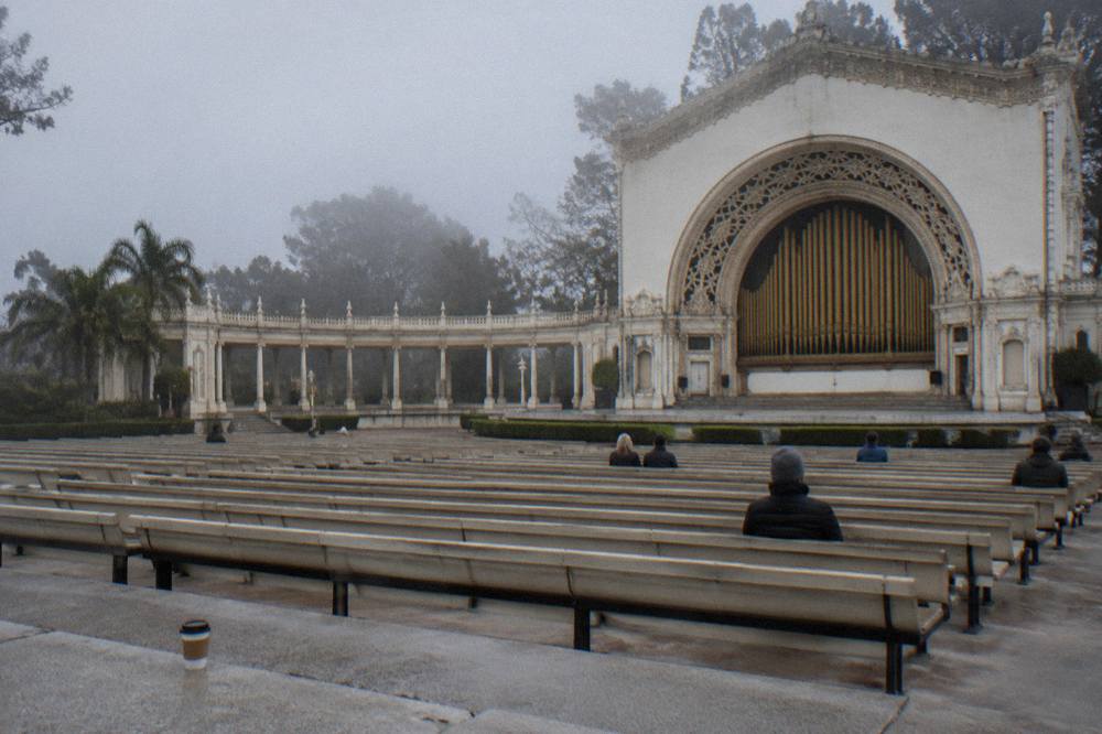 The Spreckels Organ Pavilion stage with its pipe organ and rows of empty benches in Balboa Park