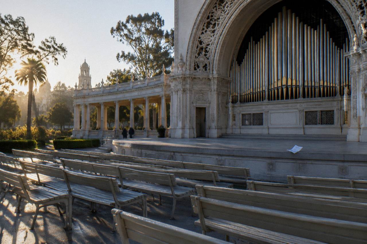 The Spreckels Organ Pavilion stage with its pipe organ and rows of empty benches in Balboa Park