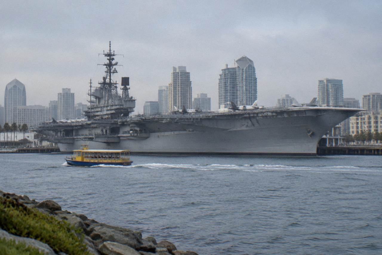 The USS Midway aircraft carrier moored at the San Diego Embarcadero with the bay behind it