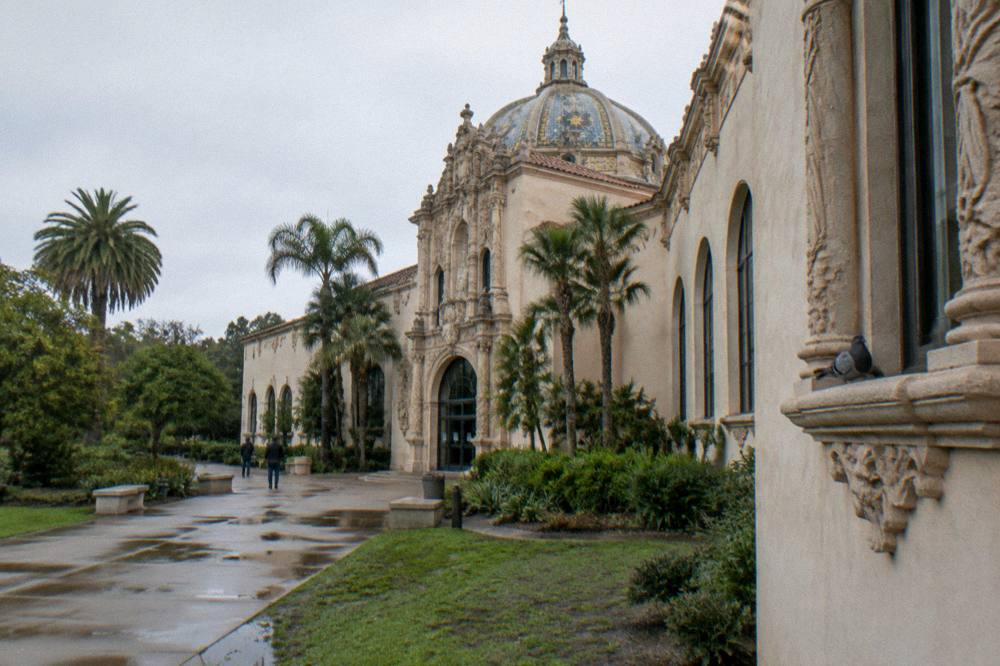 A museum facade with arched windows and tiled dome details in Balboa Park