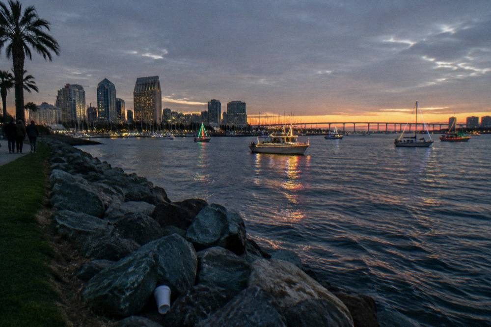 Boats on a bay at dusk with lights reflecting on the water