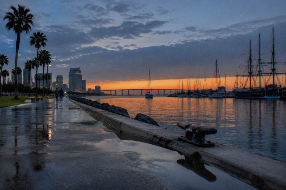 San Diego Bay at dusk with masted ships and boats along the downtown waterfront
