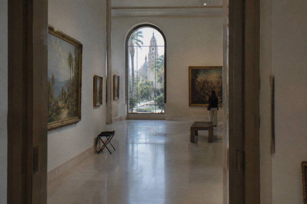 Quiet gallery hall with framed paintings on white walls
