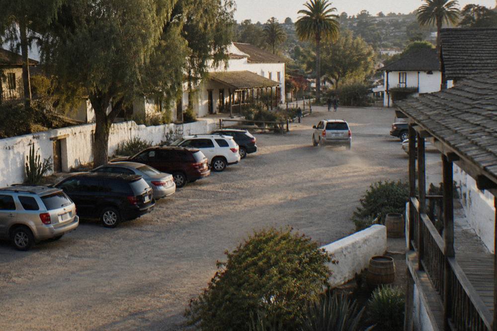 Rows of parked cars along a quiet San Diego residential street with palm trees