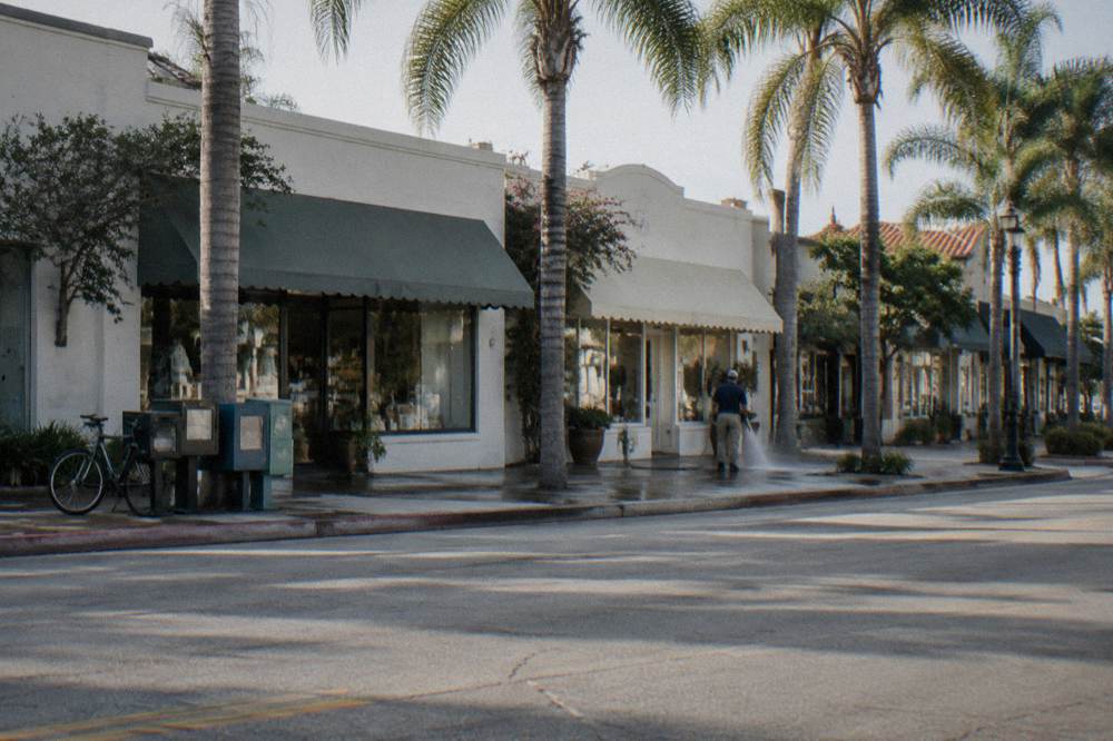 Quiet village main street with low storefronts, awnings, and sidewalk benches