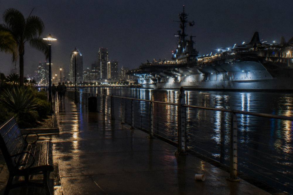The Embarcadero promenade along San Diego Bay at dusk with ships moored along the waterfront